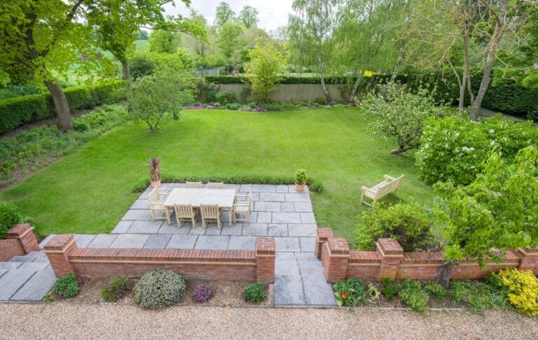 Garden patio with surrounding lawn and planted borders
