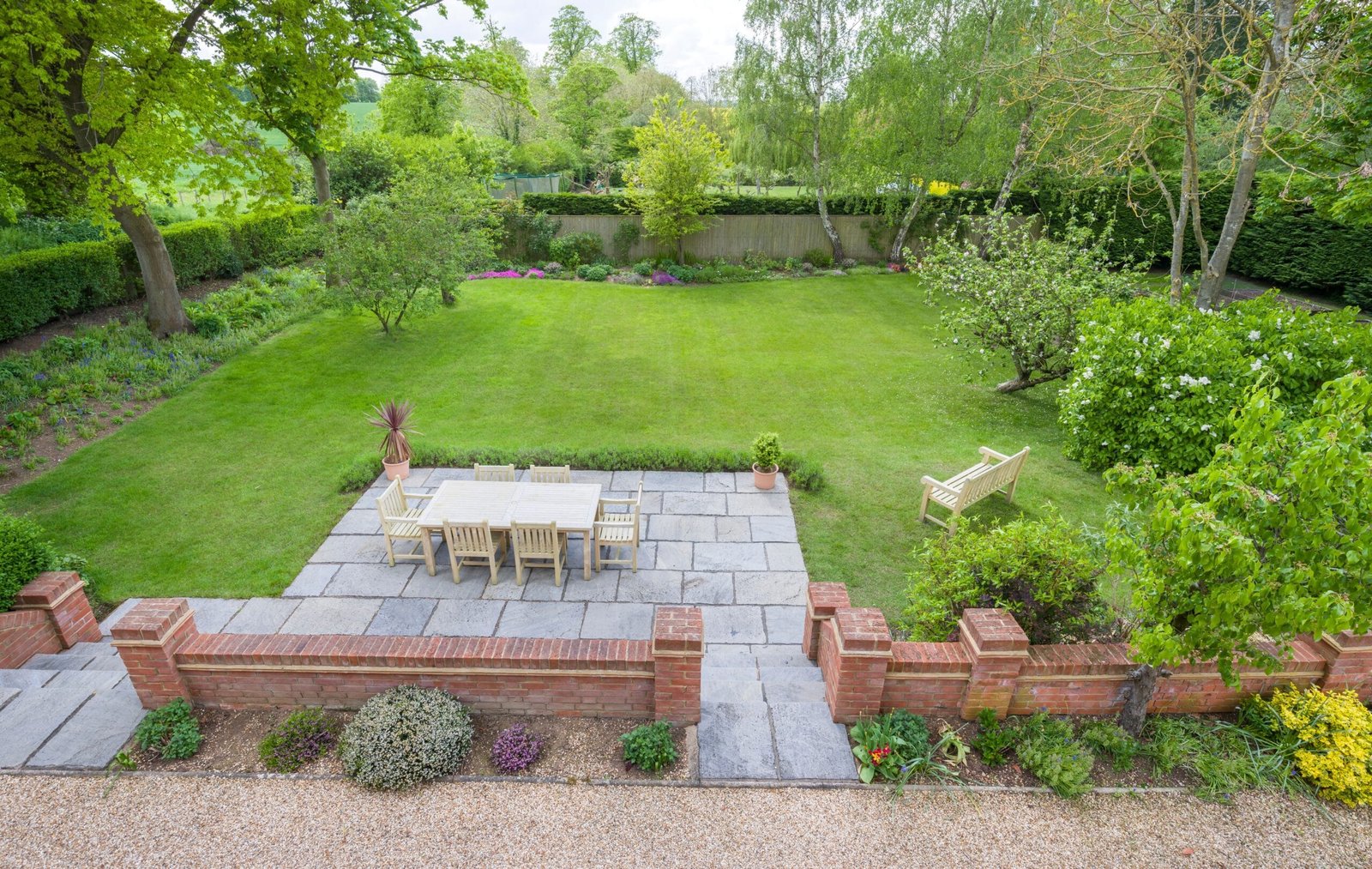 Garden patio with surrounding lawn and planted borders
